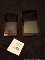 Front view of Emerson tablet and ZTE smartphone on dark surface with MaxSold lot card 244.