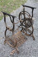 Front angled view of rusted cast iron New Home sewing machine base with foot pedal and decorative frame