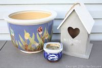 Photo showing all three items: large floral ceramic pot, small blue and white pot, and wooden birdhouse with heart cutout and welcome text.