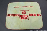 Full view of the cloth showing the printed logo and text for White Rose Gasolines and Motor Oils, cream background, red print.