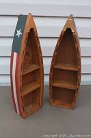 Two wooden mini canoe shelves standing upright showing American flag painted sides and internal shelves