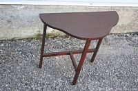 Front view of the small wooden side table showing semi-circular top and four legs connected by crossbars.
