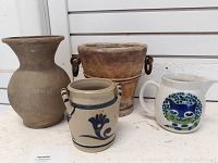 Four pottery pieces including jug, crock, pitcher, and two planters showing overall lot contents.