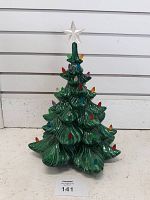 Front view of ceramic Christmas tree showing green glazed branches, colored plastic bulbs, and star topper, missing base and light.