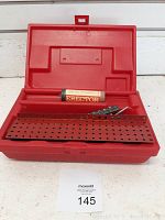 Red plastic case open showing metal Erector beams, one long with perforations, and an Erector motor unit labeled use two C batteries.