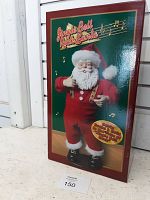 Box showing Jingle Bell Rock Santa figurine front with image of Santa in red and white suit and musical notes in background.
