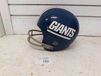 Side view of blue 1979 Rawlings NY Giants child's football helmet with white 'GIANTS' decal, gray facemask, some surface wear.