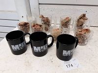 Photo showing some McDonald's Batman series and Men in Black movie mugs, arranged on a surface with packing paper inside.
