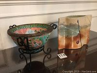 Photo showing both pottery pieces: signed rectangular vase and floral decorative bowl with stand.