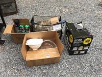 Four boxes of various party ware items including glasses, confetti poppers, party hats, plastic bowls, and plastic cups.