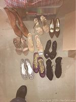 Photo showing all ladies shoes in size 8 including boots, heels, sandals, and flats in various styles and colors arranged on a beige floor.