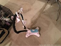 Full view of TOBI clothing steamer showing base unit with hose extended upwards on concrete floor.