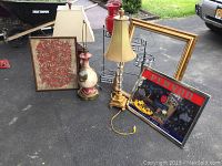 Full view showing two lamps, a red vase, large gold frame, bird picture, and Pernod mirror sign arranged outdoors