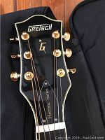 Close-up of black headstock with Gretsch logo, gold-plated tuners, Historic Series truss cover