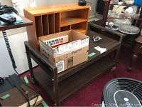 Photo showing vintage TV cart with dark wood, metal frame on caster wheels, and wooden desk organizer with art supplies on top.