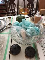 Wide shot showing entire punch bowl set with cups, fondue pot, compote bowl, onion soup bowls, and other kitchenware on table.