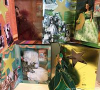 All four Scarlett O'Hara Barbie dolls shown in their original colorful open display boxes with themed backgrounds.