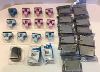 Photo showing all 26 sealed ink cartridges arranged on a surface, including multiple colors and brands.