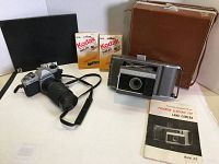 Full lot showing Pentax K1000 with 80-200mm lens, Polaroid camera in box with vintage case, Kodak mailers, and booklet.