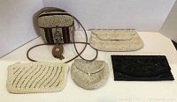 Five vintage and antique beaded purses displayed together showing different colors, shapes, and styles.
