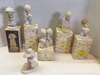 Photo showing all six vintage Precious Moments figurines along with their original boxes, arranged on a shelf with one figurine out of box.