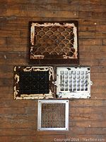 All four vent covers arranged on wooden floor, showing varying sizes and conditions.