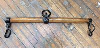 Full view of antique wooden bar with attached metal hardware.