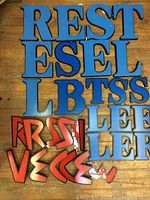 Photo of 19 blue wooden letters arranged along with 7 red wooden letters and red plastic molds on a wooden surface.