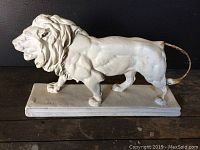 Side view of vintage lion sculpture showing detailed mane, muscular body, and rectangular base with artist mark "BARYE."