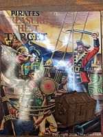 Top of the box showing a vibrant pirate battle scene with pirates firing cannons and a treasure chest image.