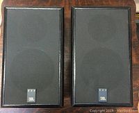 Pair of black grille JBL 500 speakers with wooden frame, front view