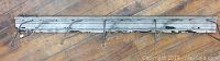 Front view of the wooden coat rack showing all eight metal hooks and distressed paint on the wooden base.