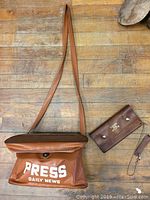 Full view of vintage vinyl press bag and Toronto Star billfold on wooden floor