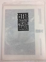 Image of packaging for the 'Clear and Present Danger' promotional photo set, showing branded cover with movie title.