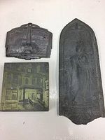 Three vintage metal pieces: Paris souvenir plaque, metal print stamp, and Indian decorative plaque