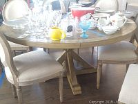 Round wood dining table shown with chairs and accessories removed