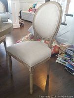 Front angle view of one chair showing oval back and seat.