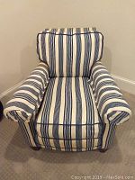 Front view of the blue and ivory striped upholstered armchair showing cushioned seat, armrests, and back.
