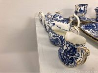 Tea set items side view showing teapot, cream jug, sugar bowl, and gravy boat in Blue Mikado pattern with gold trim.