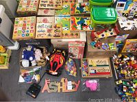 Overview photo showing assortment of kids toys including puzzles, stuffed animals, and electric car.