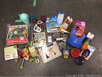 Overview of all baby gear items including boxed mirror, toys, bib, drink cups, and books.