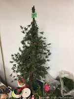 Artificial Christmas tree 39 inches tall with pinecone decorations, sparse branches.