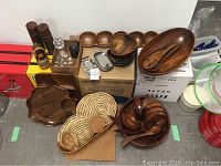 Photo showing wooden serving bowls including segmented trays, vintage salt and pepper shakers, woven hot pads and stainless steel trays.