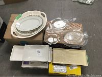 Photo of assorted ceramic and glass serving plates and platters, varied sizes and shapes.