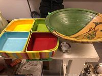 Photo showing colorful ceramic appetizer tray with four compartments and decorative ceramic fruit bowl with fish design
