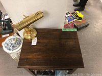 Top view of the telephone desk showing dark wood finish and brass bankers lamp on top.
