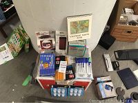 Overview of pens, pencils, calendar, stapler, small notebooks, and other stationery items stacked on boxes.