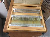 Wooden slide case open with glass slides in metal racks