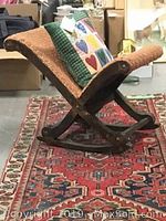Side view of gout chair resting on runner, showing frame shape and runner field pattern
