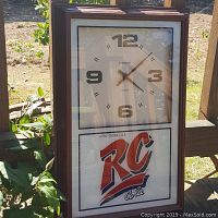 Full view of the vintage wall clock featuring the RC Cola logo with wooden frame and glass front.